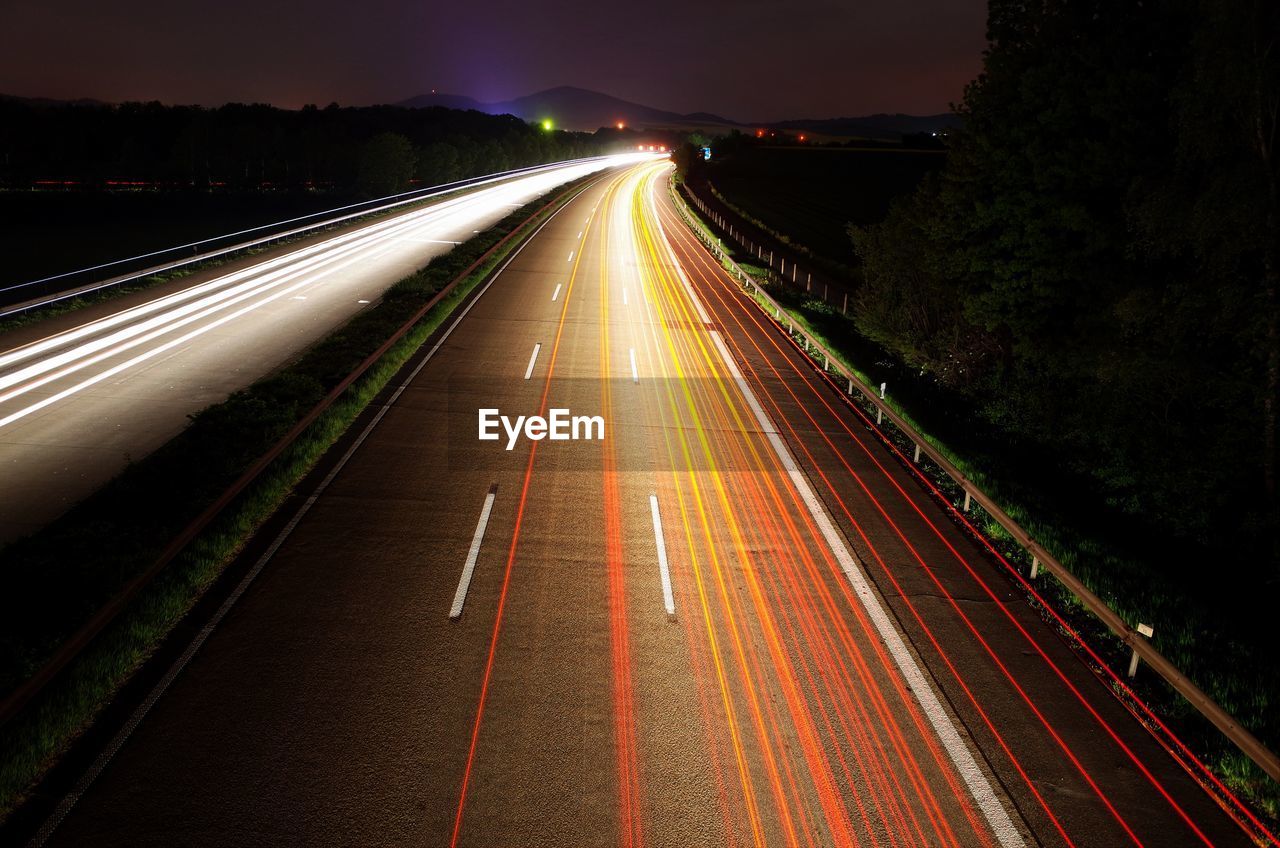 High angle view of light trail on highway against sky at night