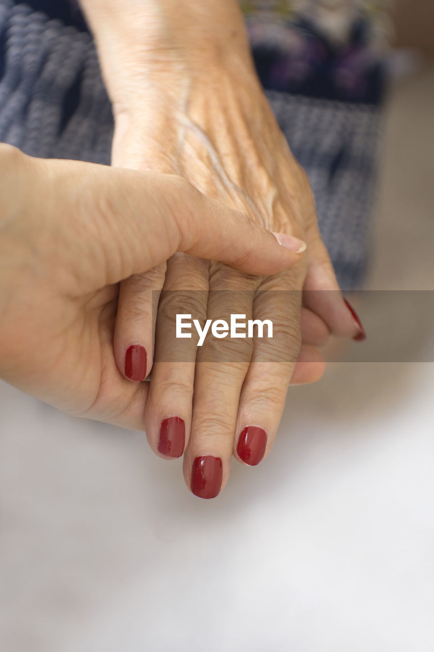 High angle view of hands with red nail polish