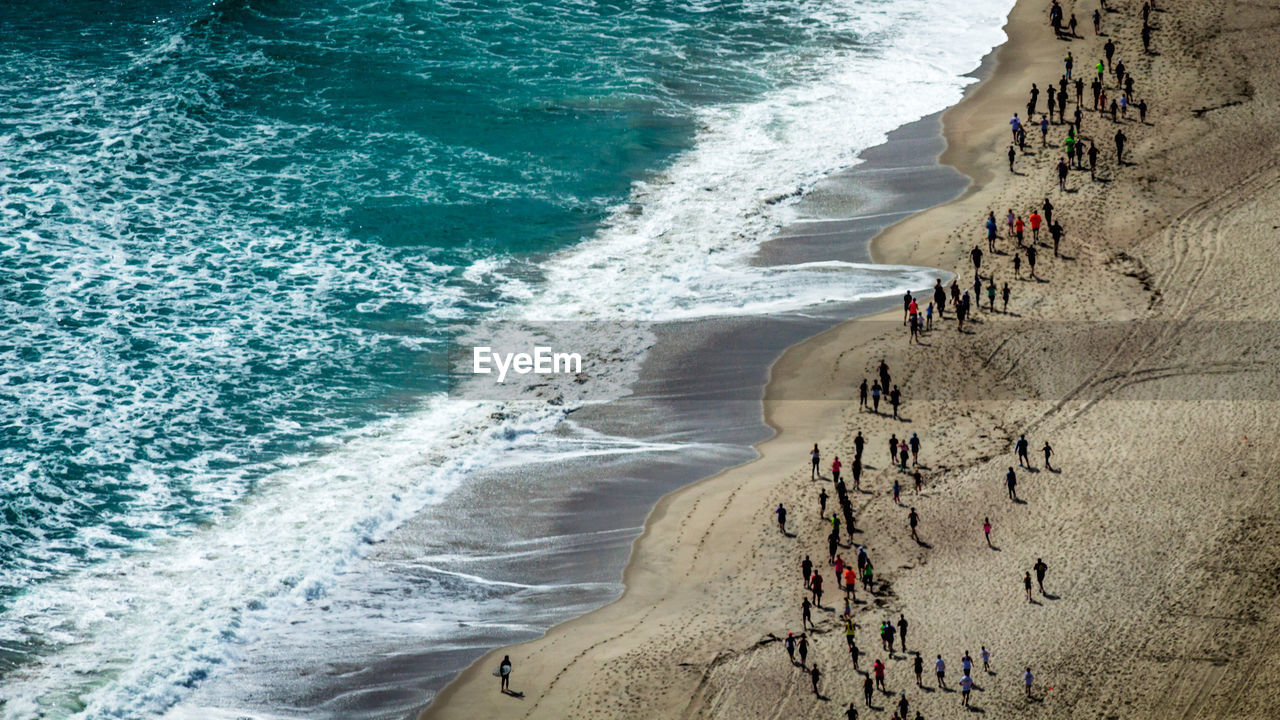 High angle view of people running on shore at beach