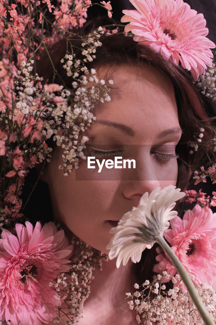 Close-up of beautiful woman smelling flowers