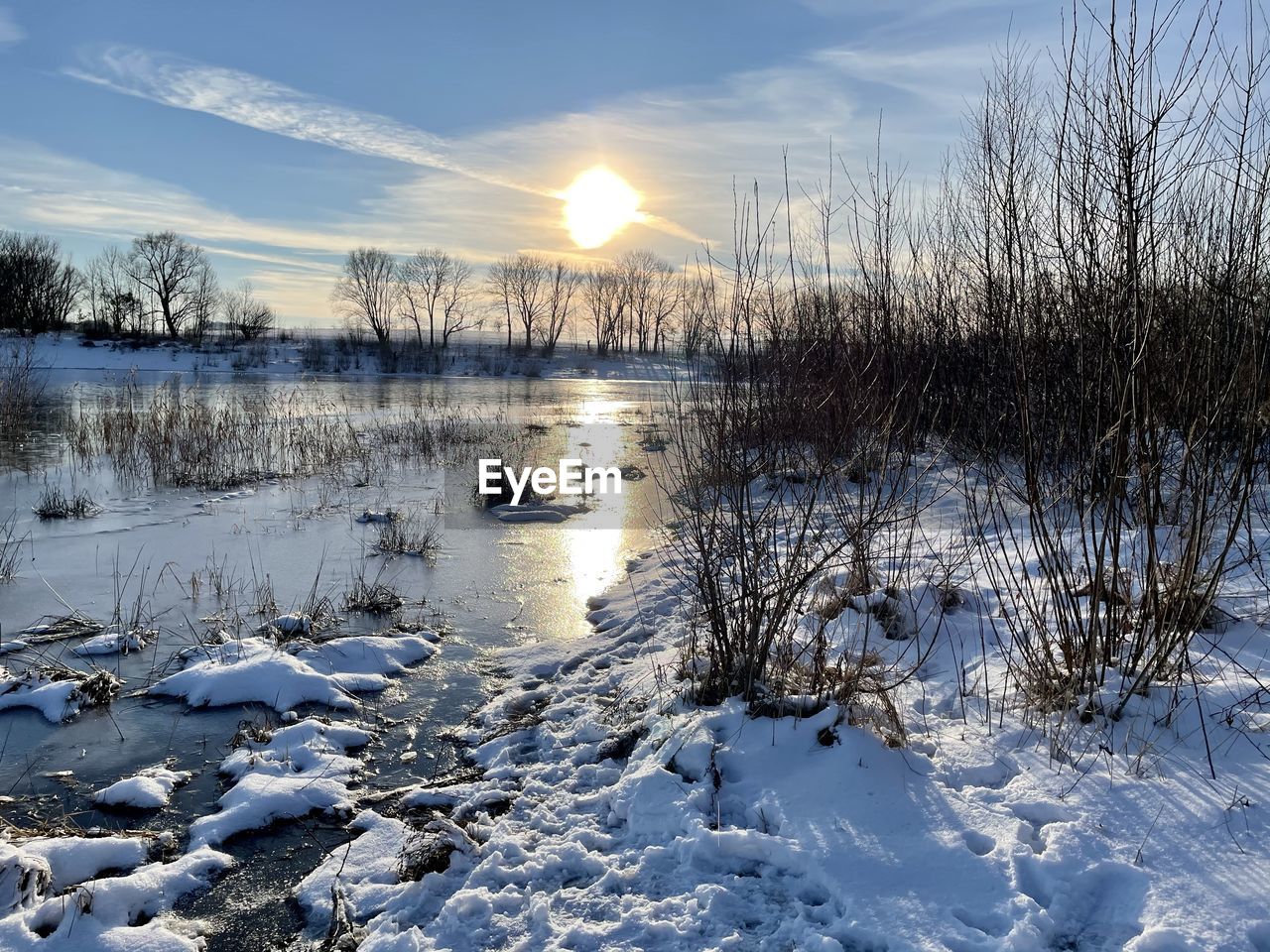 FROZEN LAKE AGAINST SKY DURING SUNSET