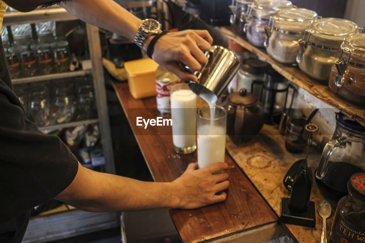 Midsection of man preparing drink