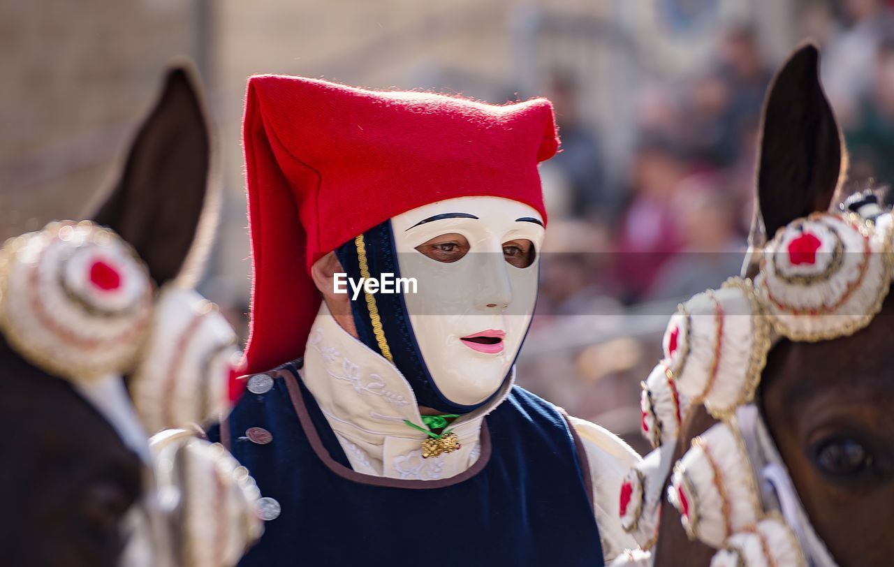 CLOSE-UP OF TRADITIONAL MASK AGAINST TREES