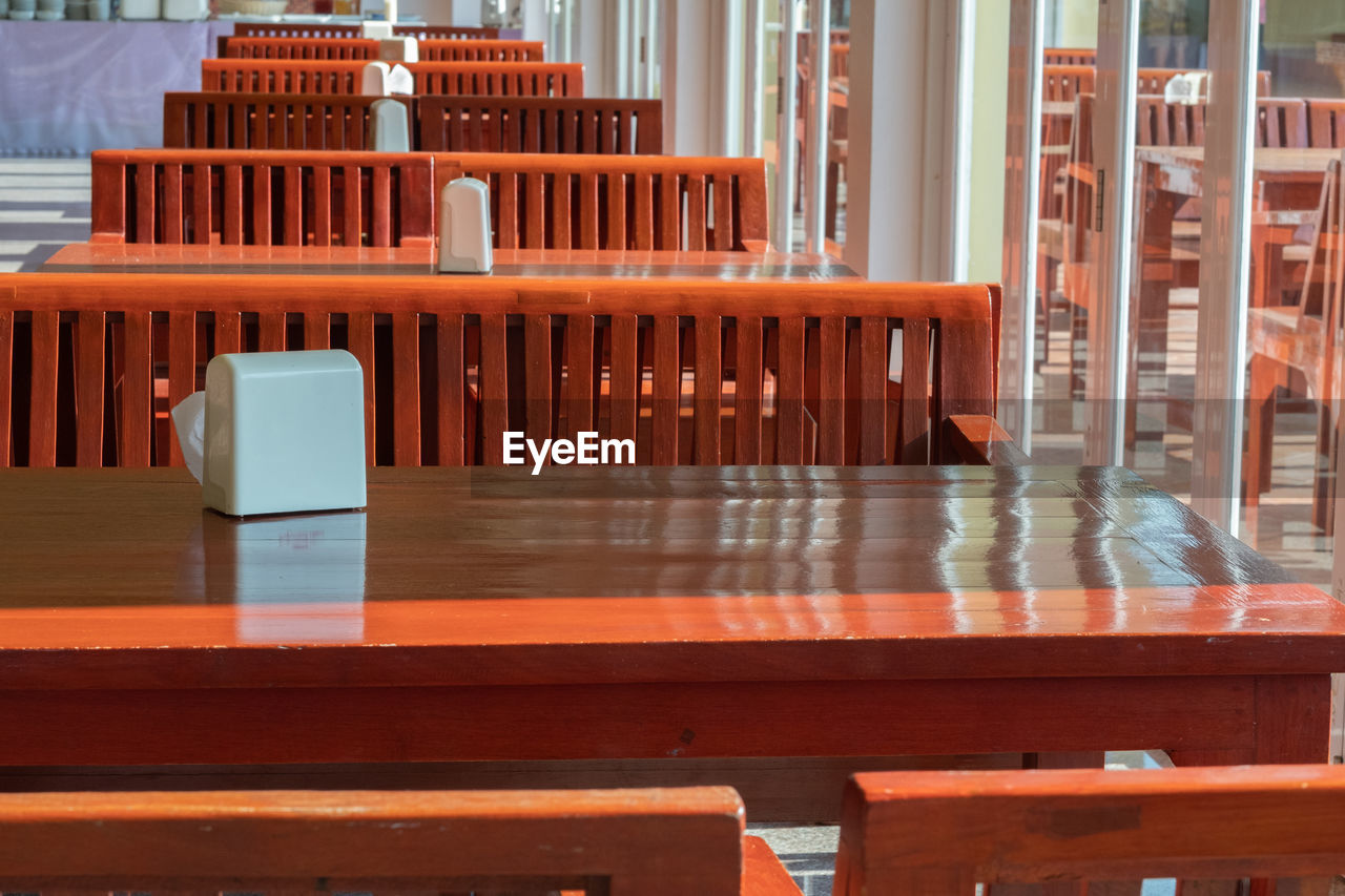 EMPTY CHAIRS AND TABLE IN CAFE AGAINST BUILDING