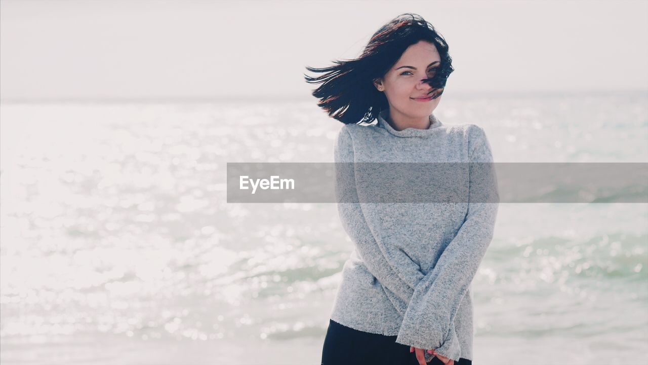 Portrait of woman standing against sea