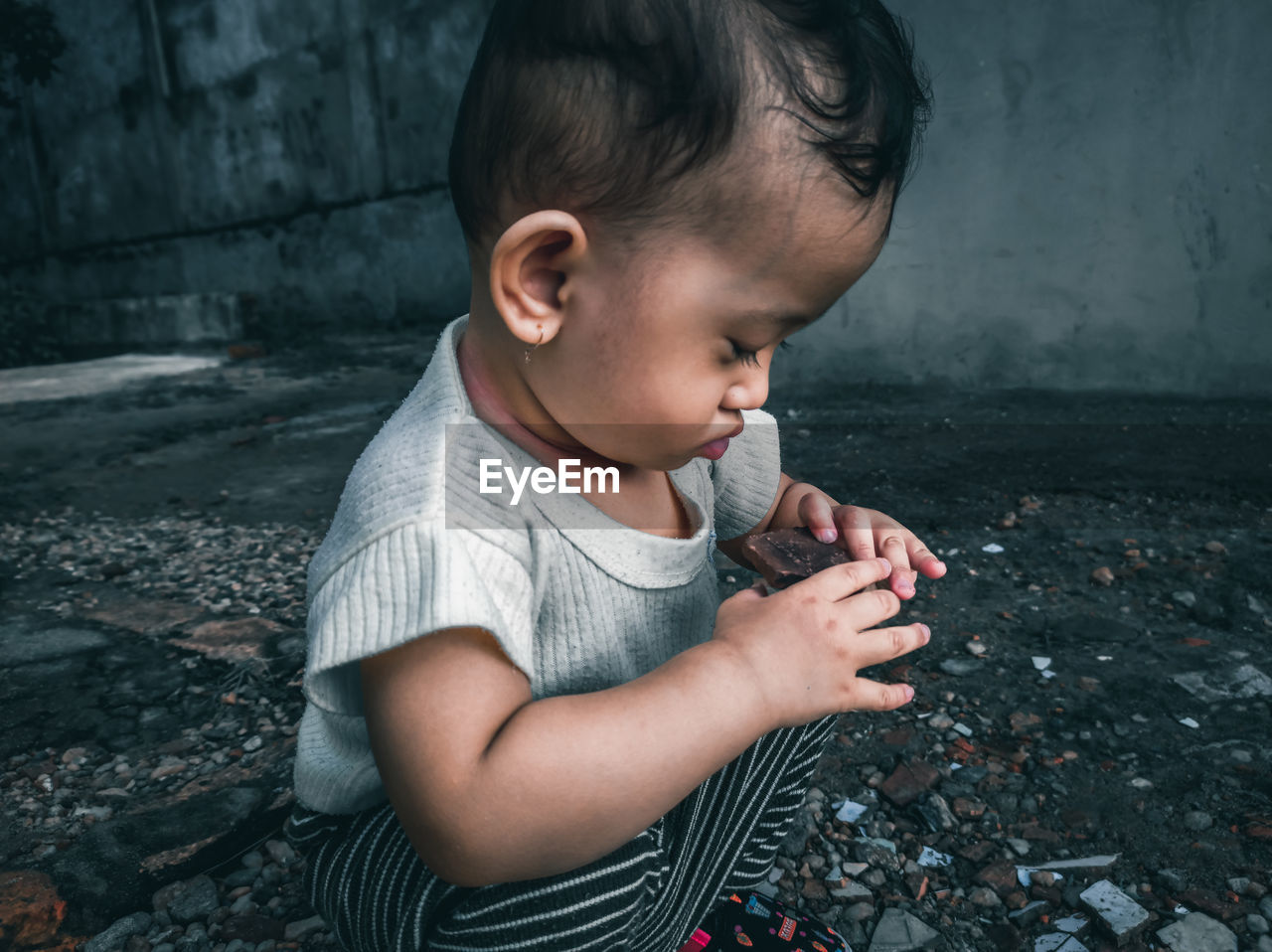 Little ana was playing stones scattered on the ground