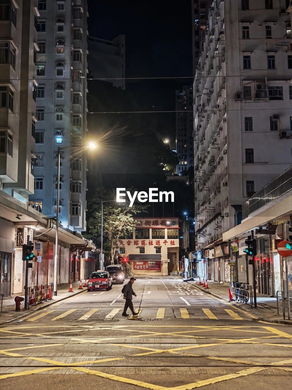 architecture, city, urban area, building exterior, built structure, street, road, downtown, cityscape, transportation, night, illuminated, city street, metropolitan area, lane, city life, metropolis, road marking, infrastructure, street light, sign, skyscraper, building, mode of transportation, town, motion, marking, evening, crosswalk, neighbourhood, lighting, nature, crossing, the way forward, symbol, travel destinations, outdoors, zebra crossing, light, residential district, car, adult, men, motor vehicle, lifestyles