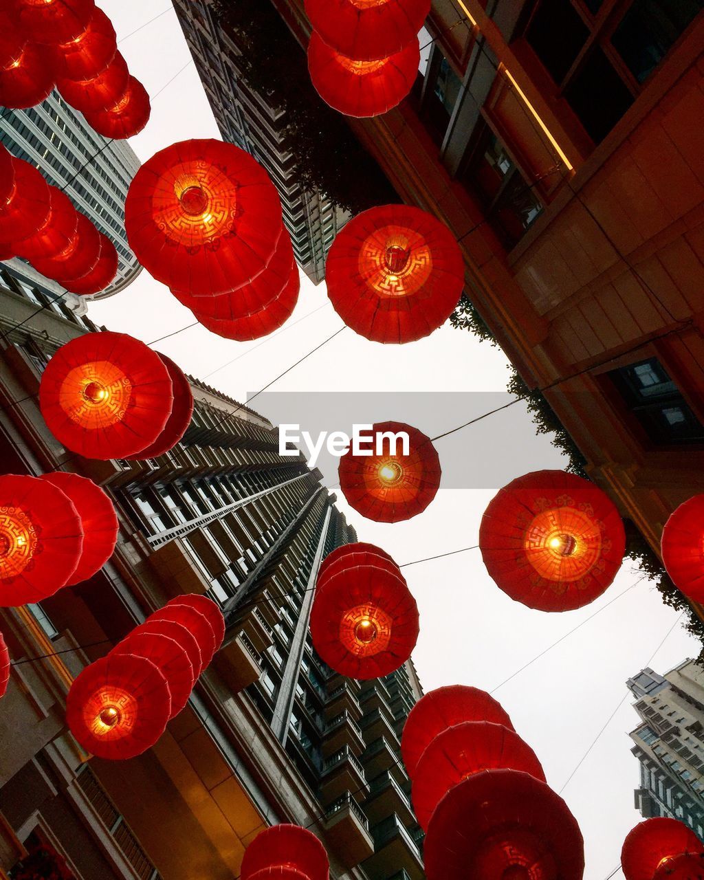 Directly below shot of illuminated lanterns hanging by buildings