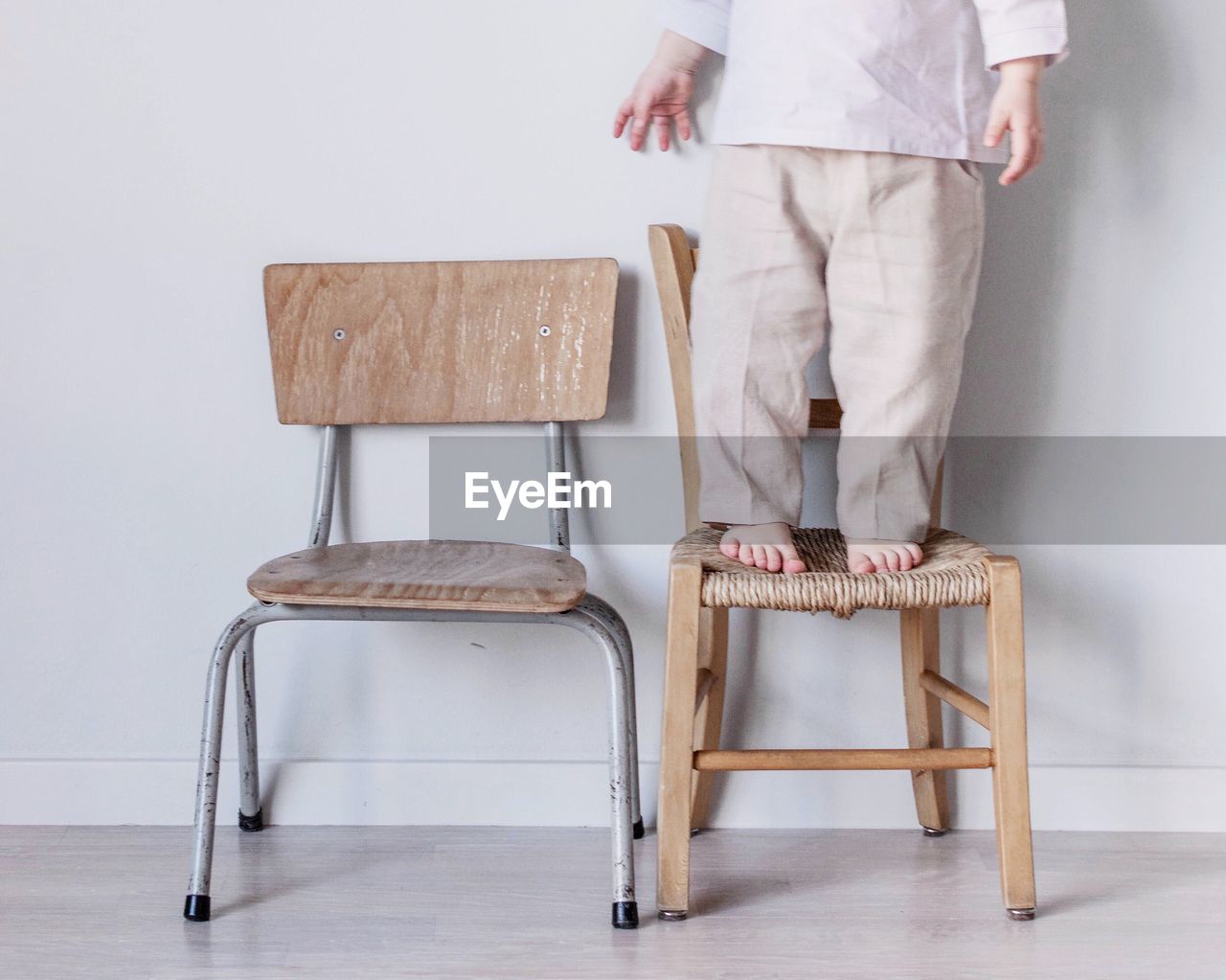 Low section of child standing on chair