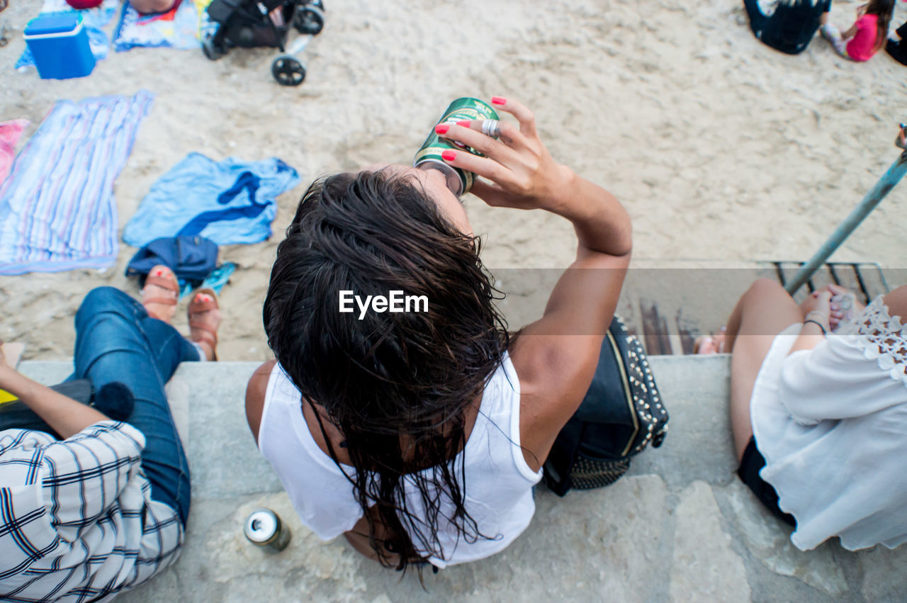 Woman drinking beer at the beach