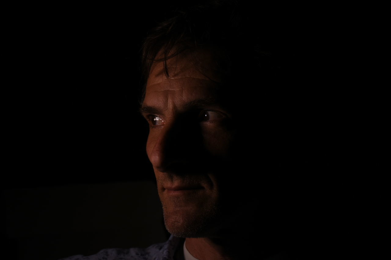Close-up of thoughtful man looking away at night