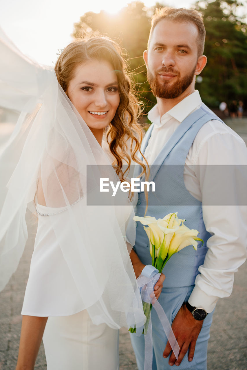 Portrait of smiling young couple standing outdoors