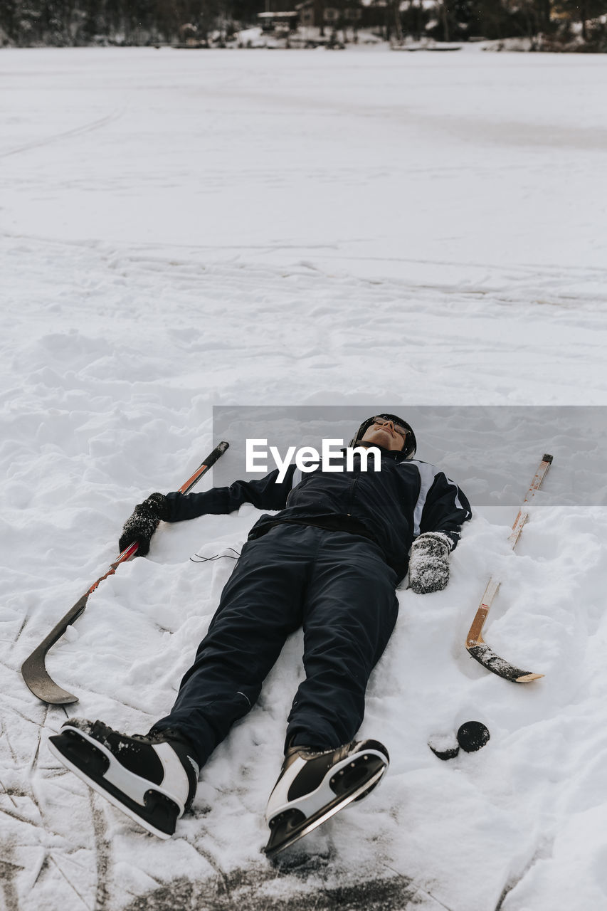 Smiling man lying on snow