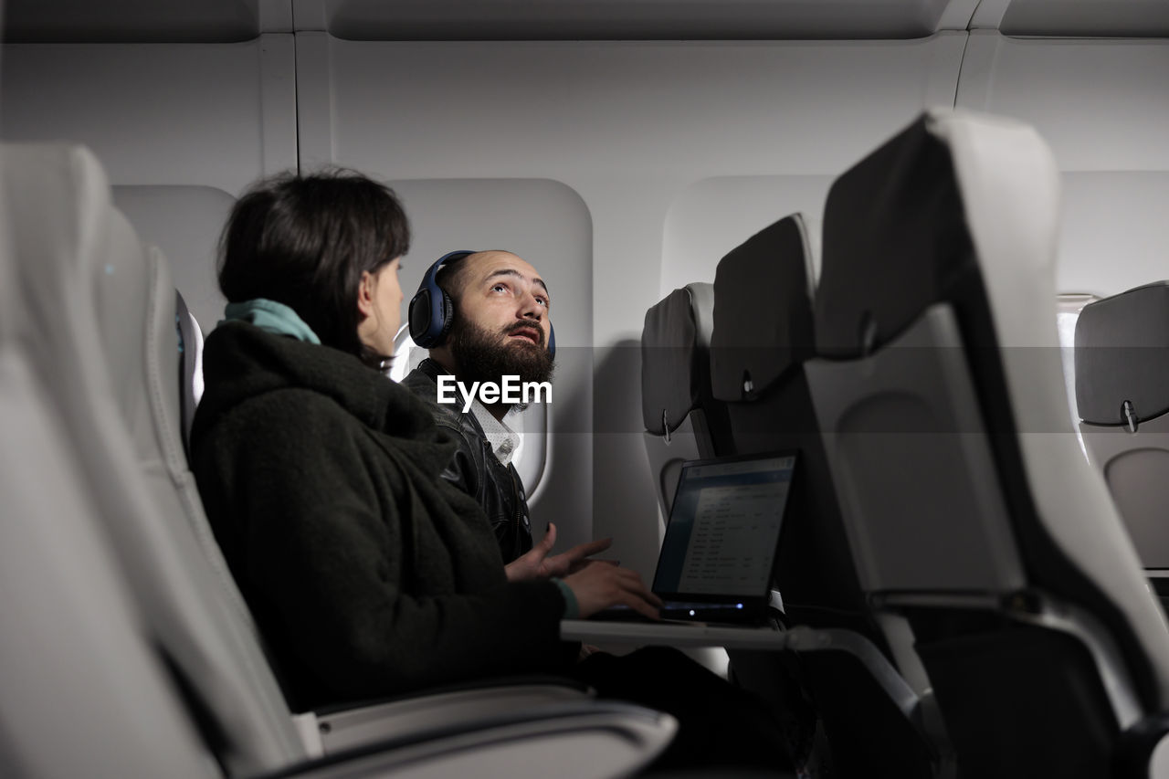 rear view of businessman using laptop while sitting in car