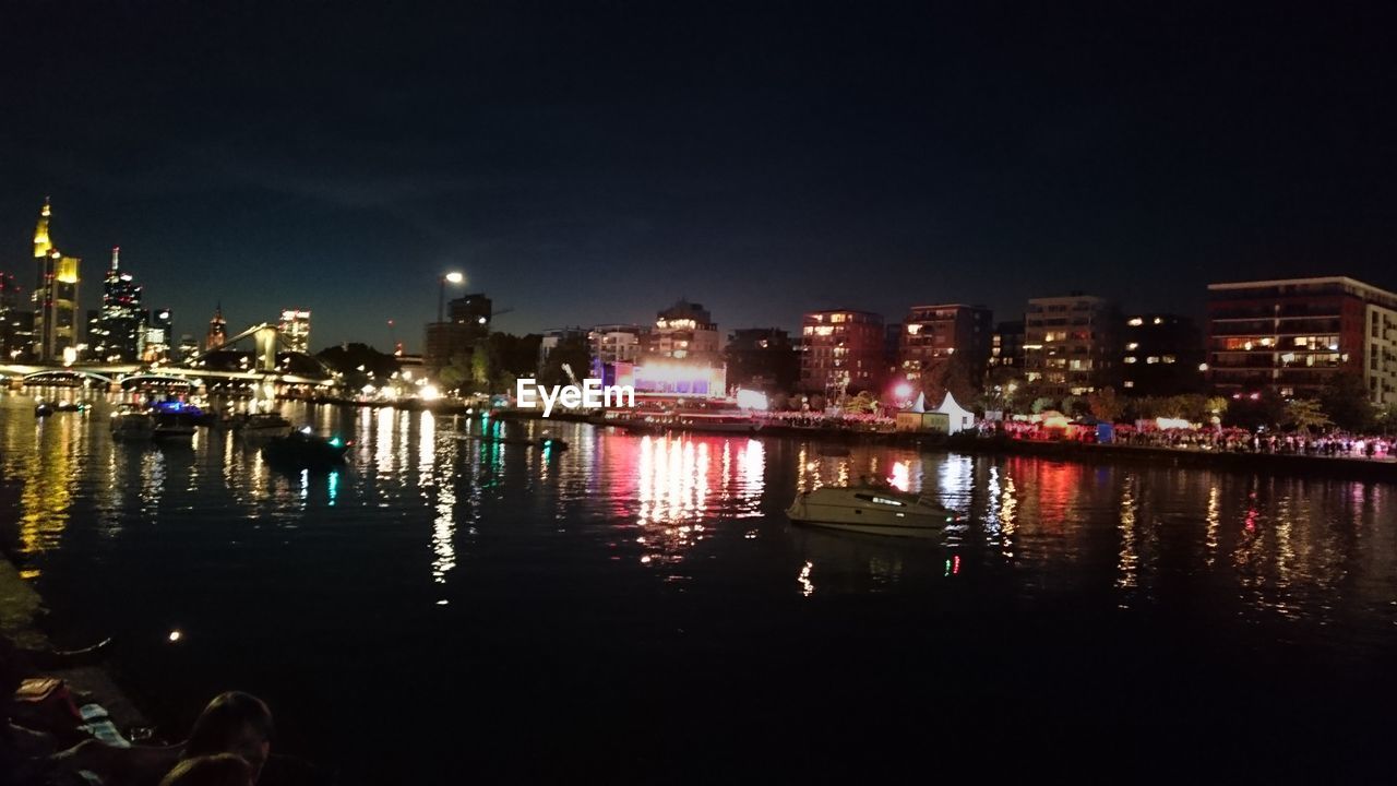 BOATS IN RIVER WITH CITY IN BACKGROUND