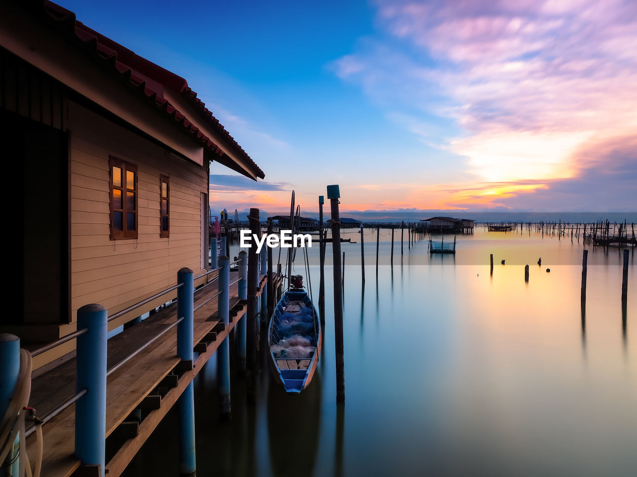 Wooden posts on building against sky during sunset