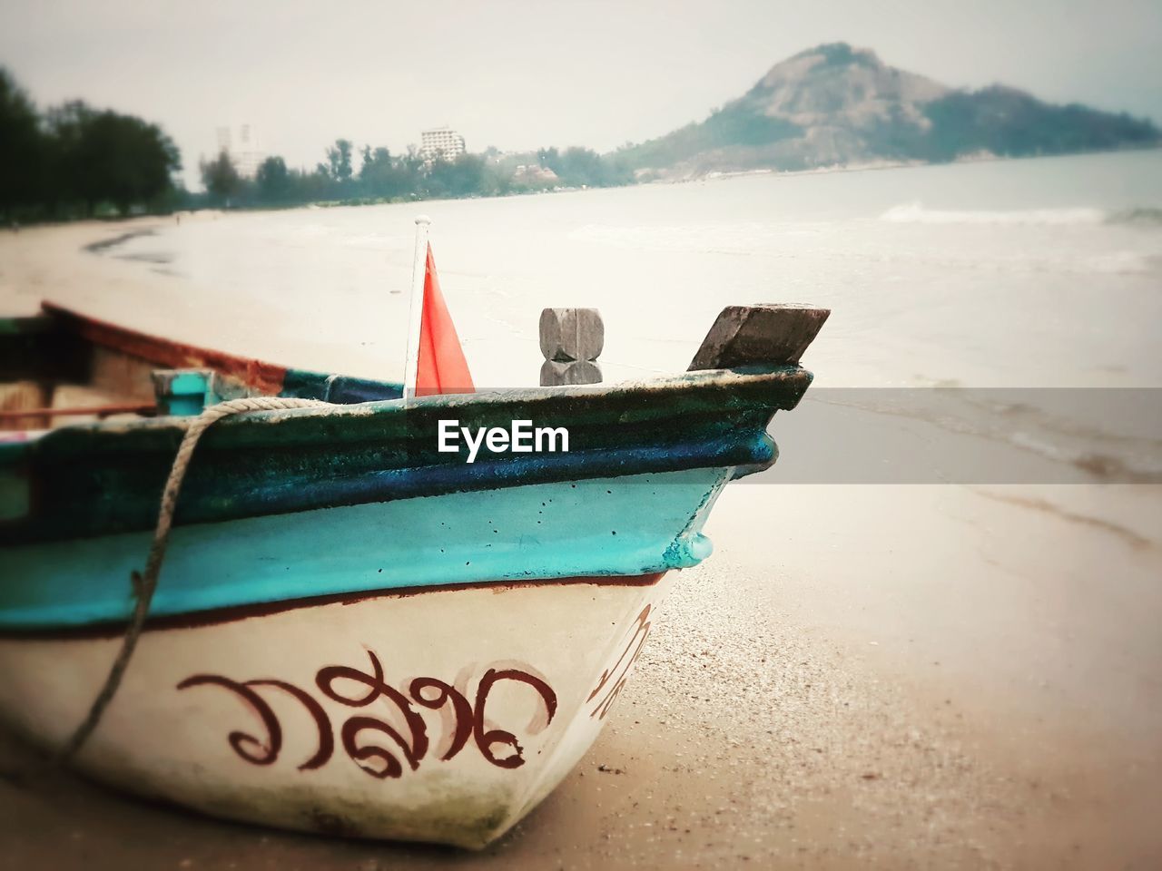 CLOSE-UP OF BOAT MOORED ON BEACH