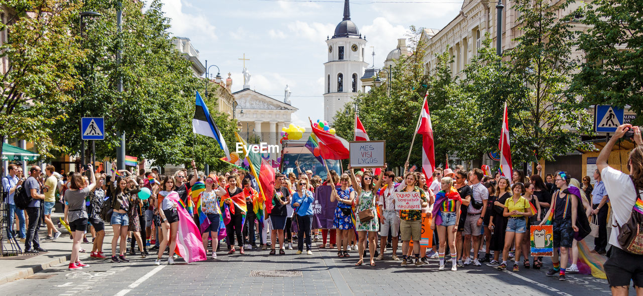 GROUP OF PEOPLE ON STREET AGAINST BUILDINGS