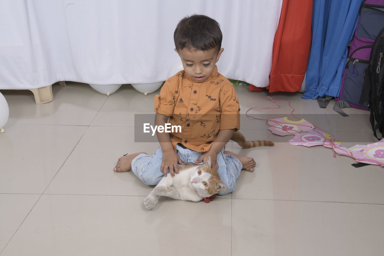 High angle view of boy sitting on floor at home