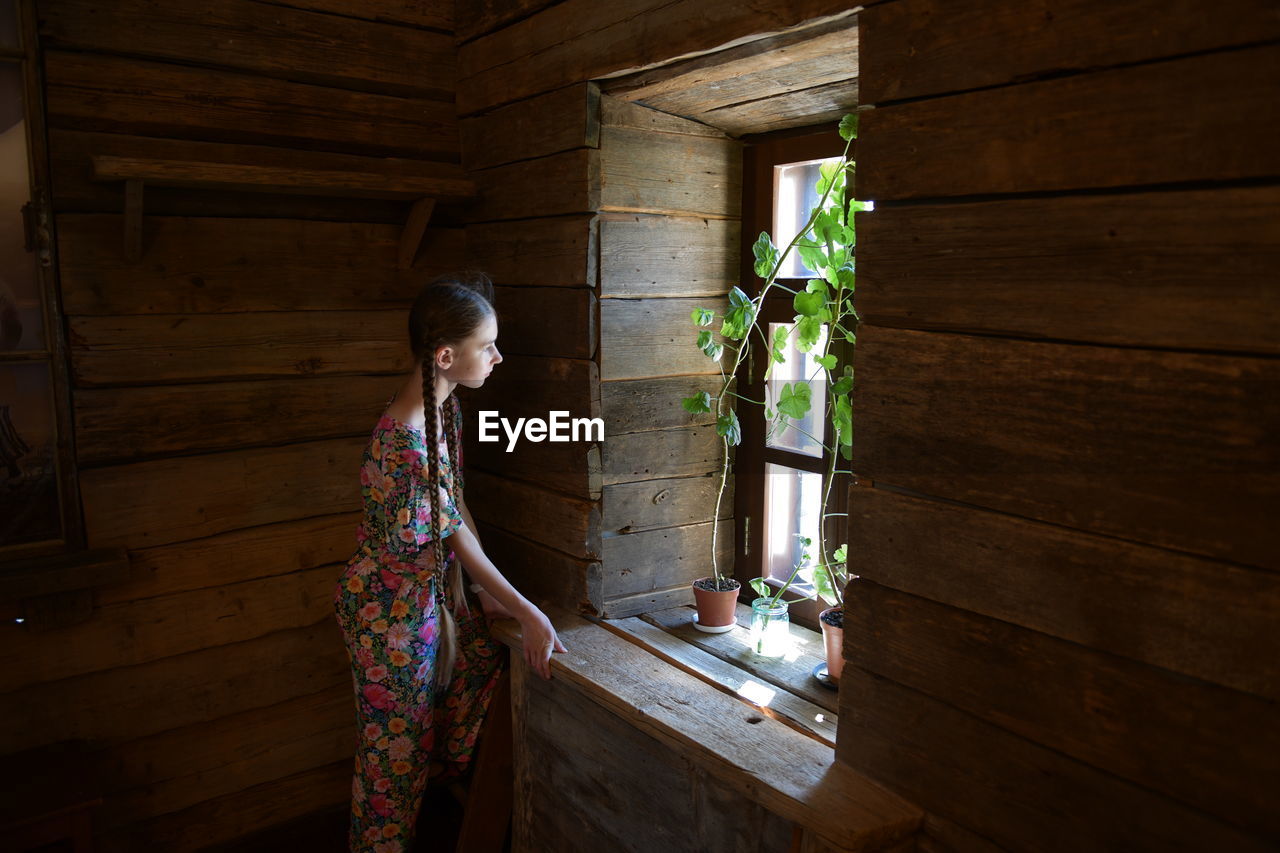 Woman looking at potted plant