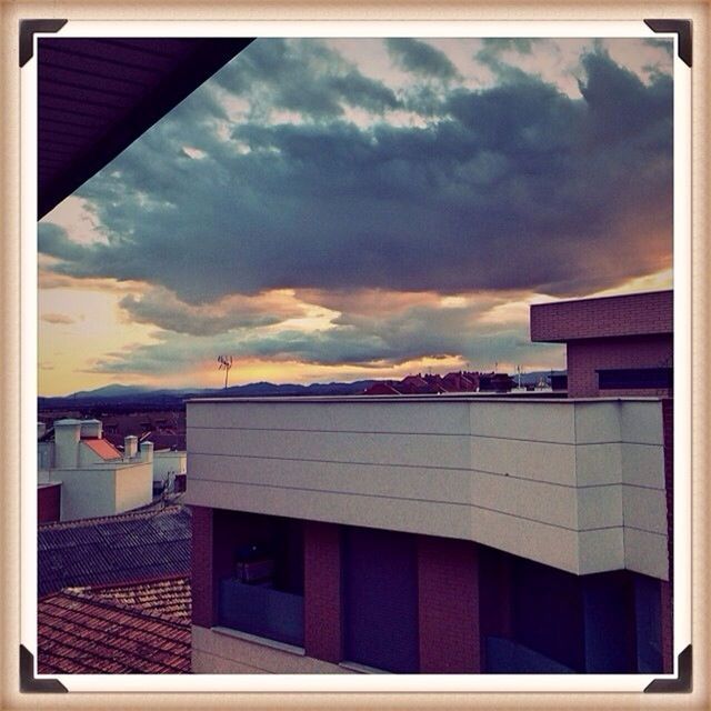 HOUSES AGAINST CLOUDY SKY AT SUNSET