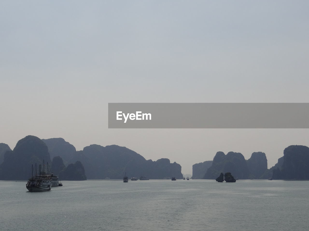 SCENIC VIEW OF SEA AND MOUNTAINS AGAINST CLEAR SKY