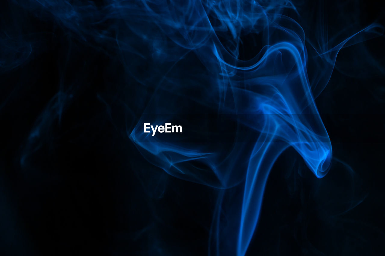 Close-up of blue smoke against black background