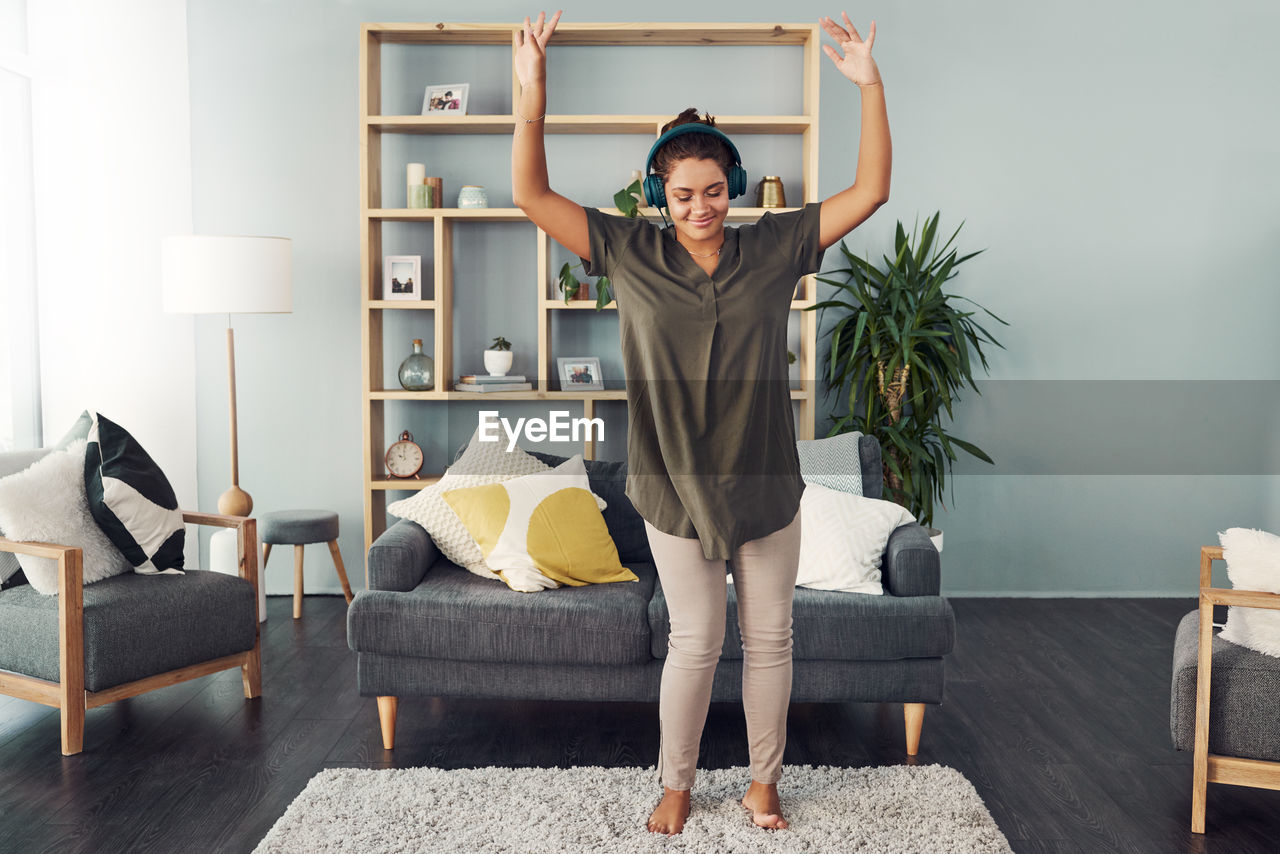 Woman standing on sofa at home