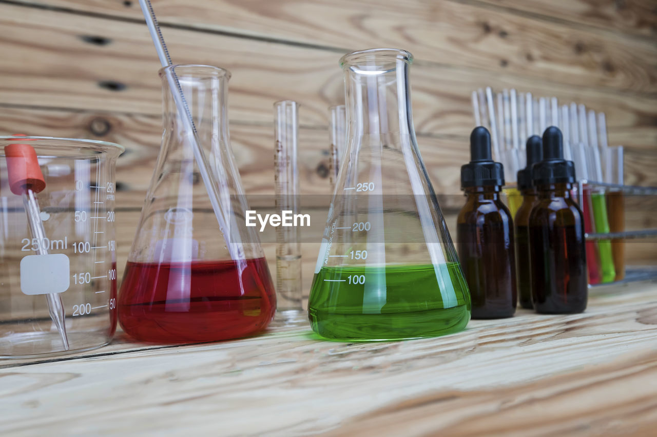 research, indoors, container, science, glass, scientific experiment, no people, education, laboratory, healthcare and medicine, laboratory glassware, wood, chemistry, bottle, table, test tube, glass bottle, still life, biochemistry, drinkware, drink, close-up