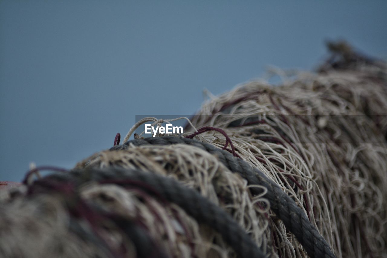 Close-up of fishing net against clear blue sky