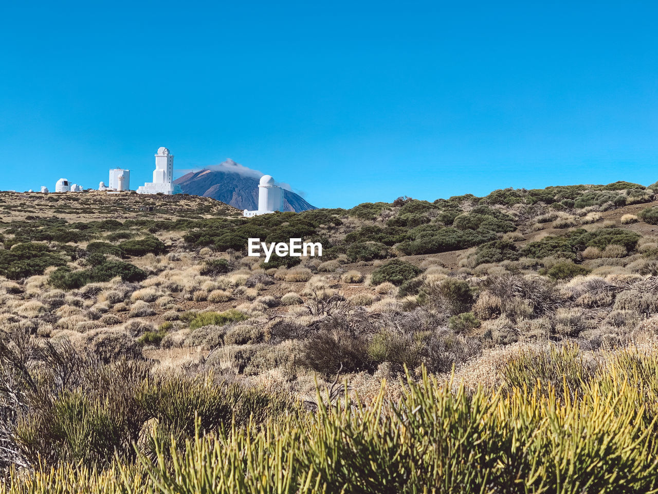 Scenic view of teide observatory and mountain summit against clear blue sky