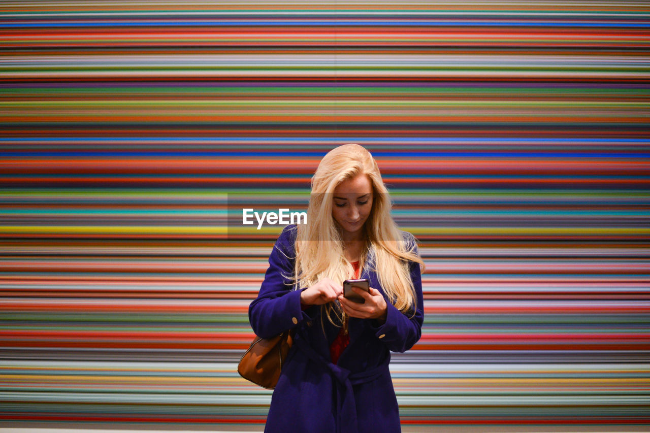 PORTRAIT OF YOUNG WOMAN PHOTOGRAPHING