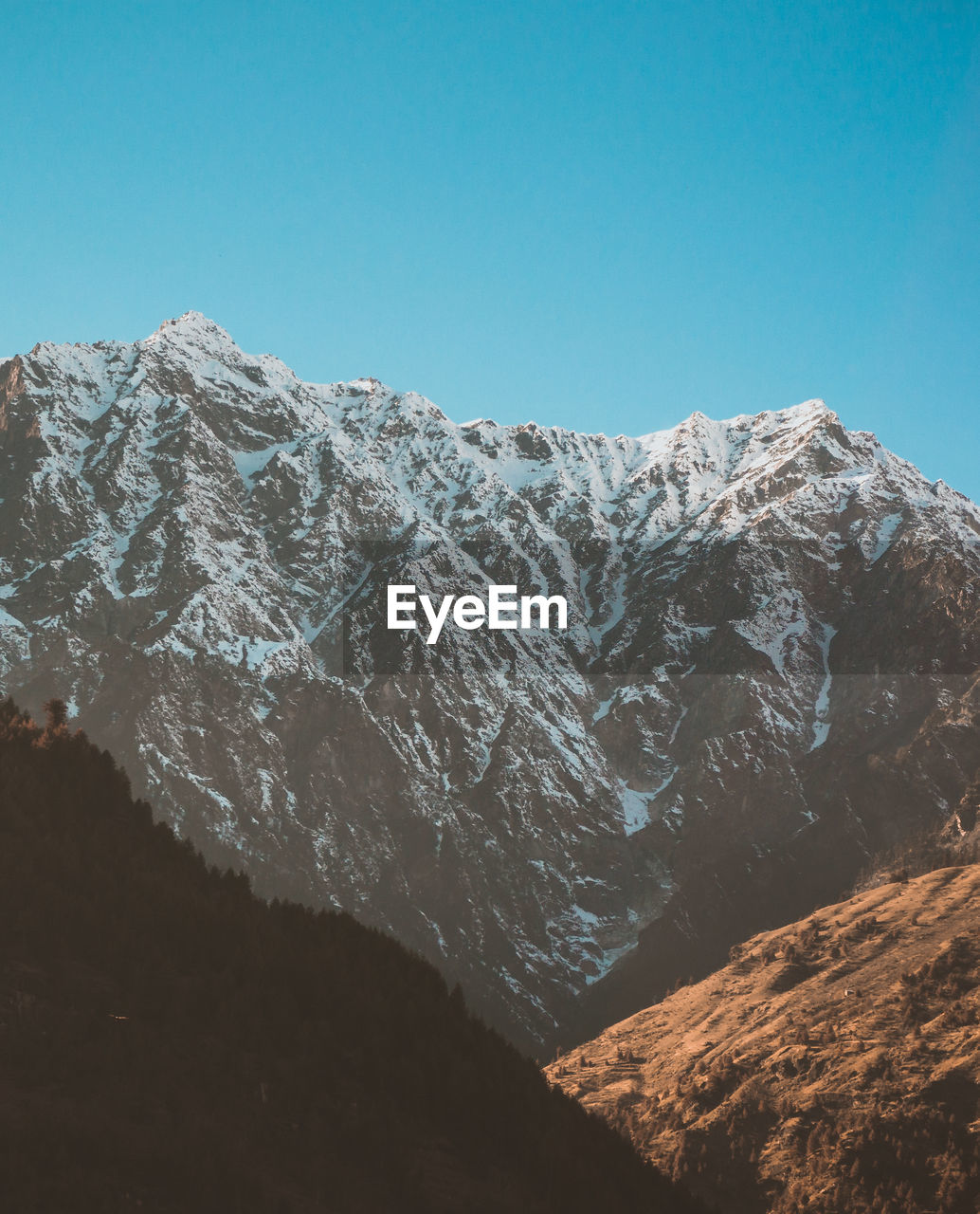 Scenic view of snowcapped mountains against clear blue sky