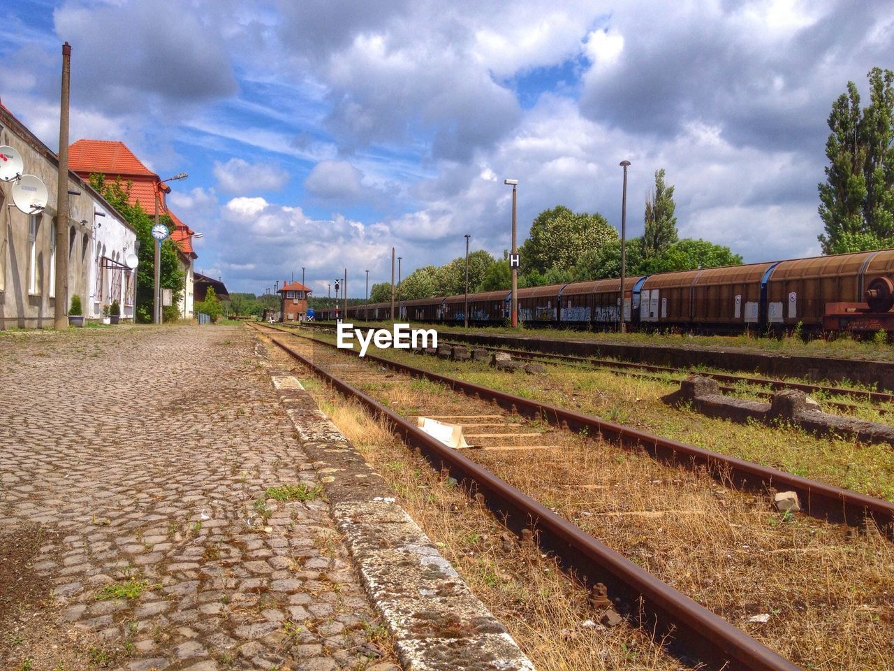 Railroad tracks against cloudy sky