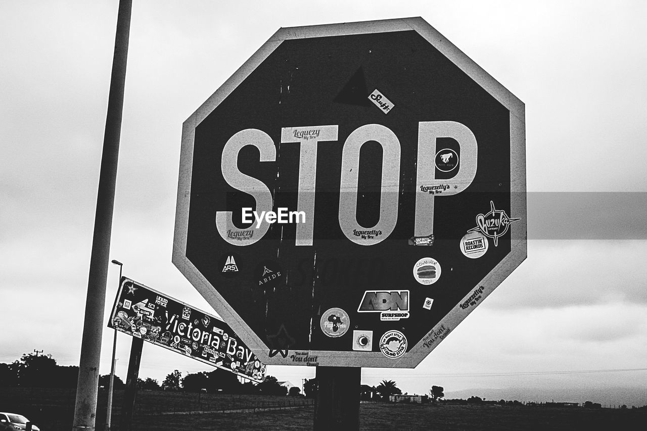 CLOSE-UP OF ROAD SIGN AGAINST SKY