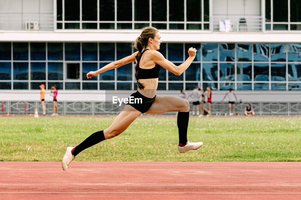 full length of young woman playing with ball on field