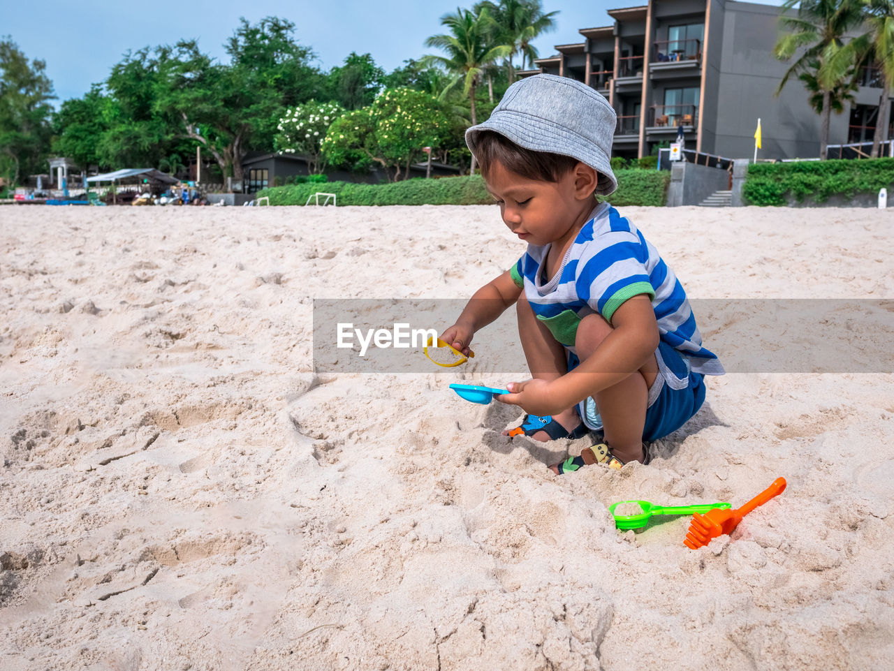 Boy playing with toy on sandy beach