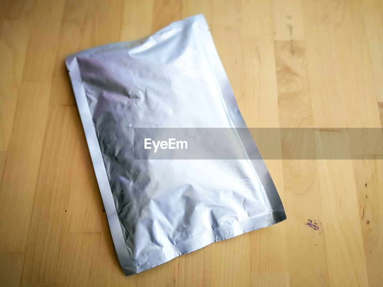 High angle view of plastic foil bag on hardwood floor