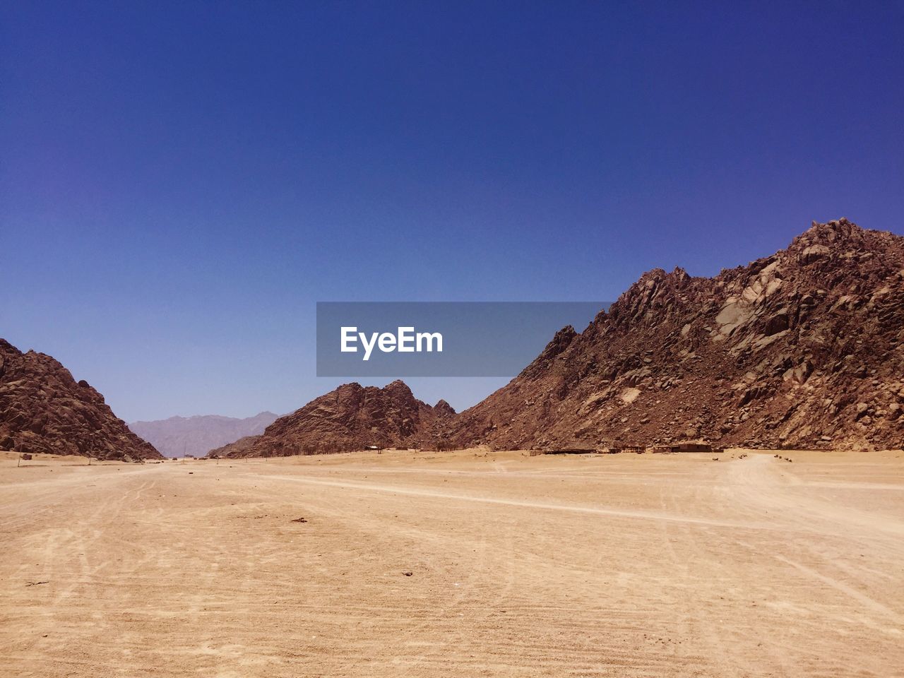 Scenic view of desert against clear blue sky