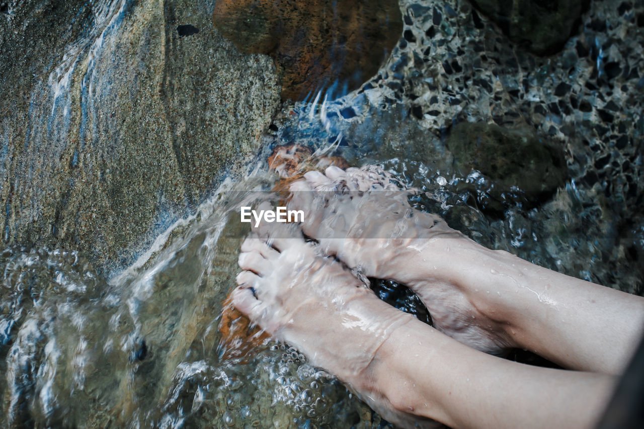 Low section of woman feet in stream