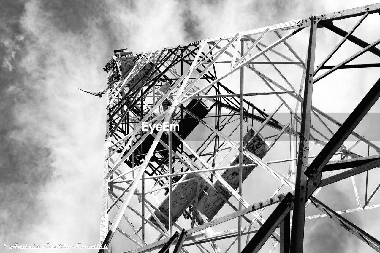 Low angle view of an old radio tower against sky in black and white
