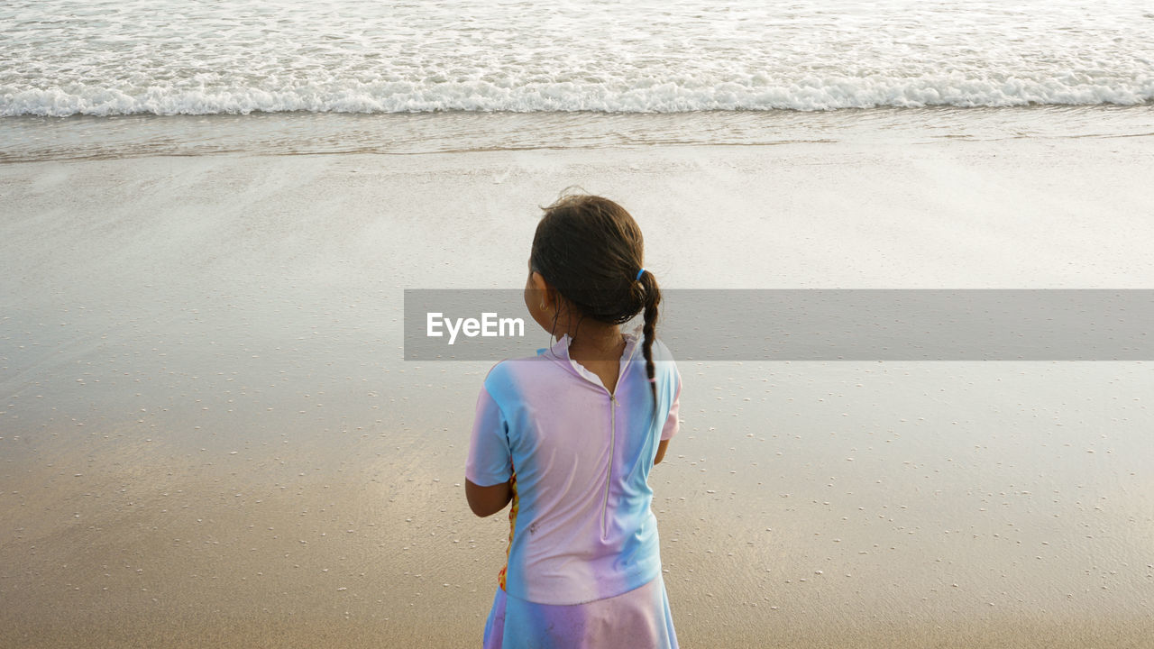 A little girl is playing on the beach