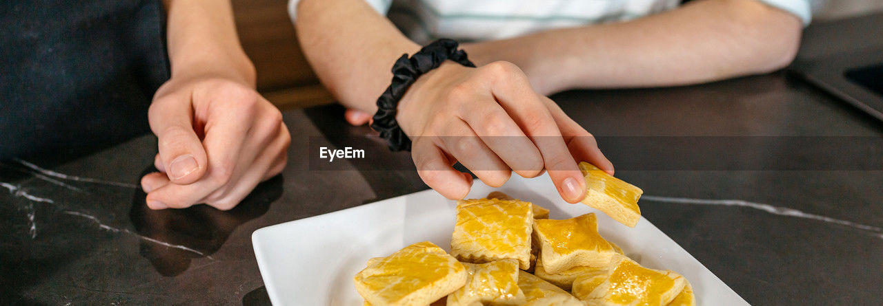 food and drink, food, hand, adult, women, indoors, freshness, one person, yellow, midsection, close-up, table, italian food, healthy eating, lifestyles, pasta, holding, business, kitchen, fast food, high angle view, men, wellbeing