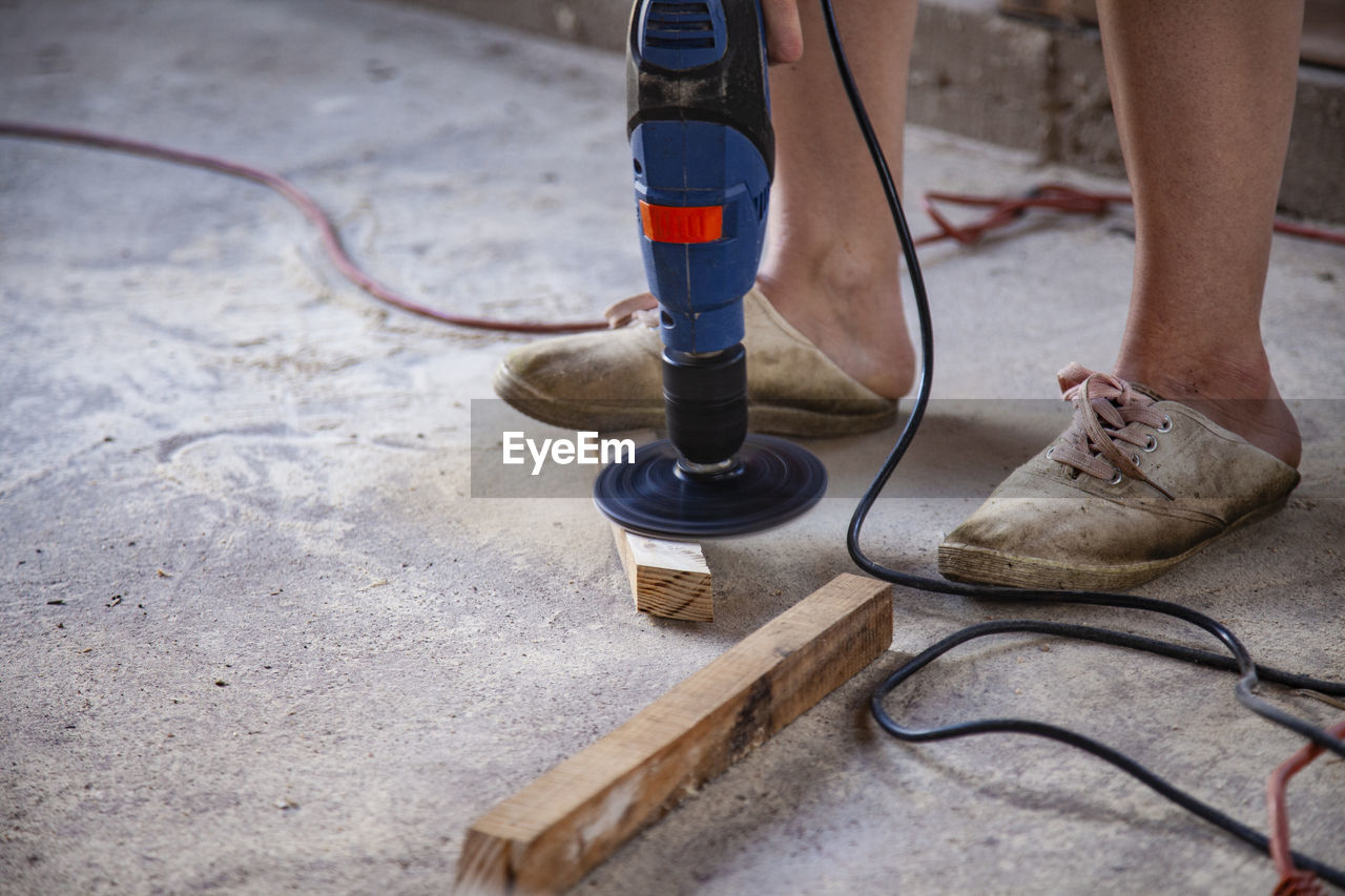 Low section of person cutting wood