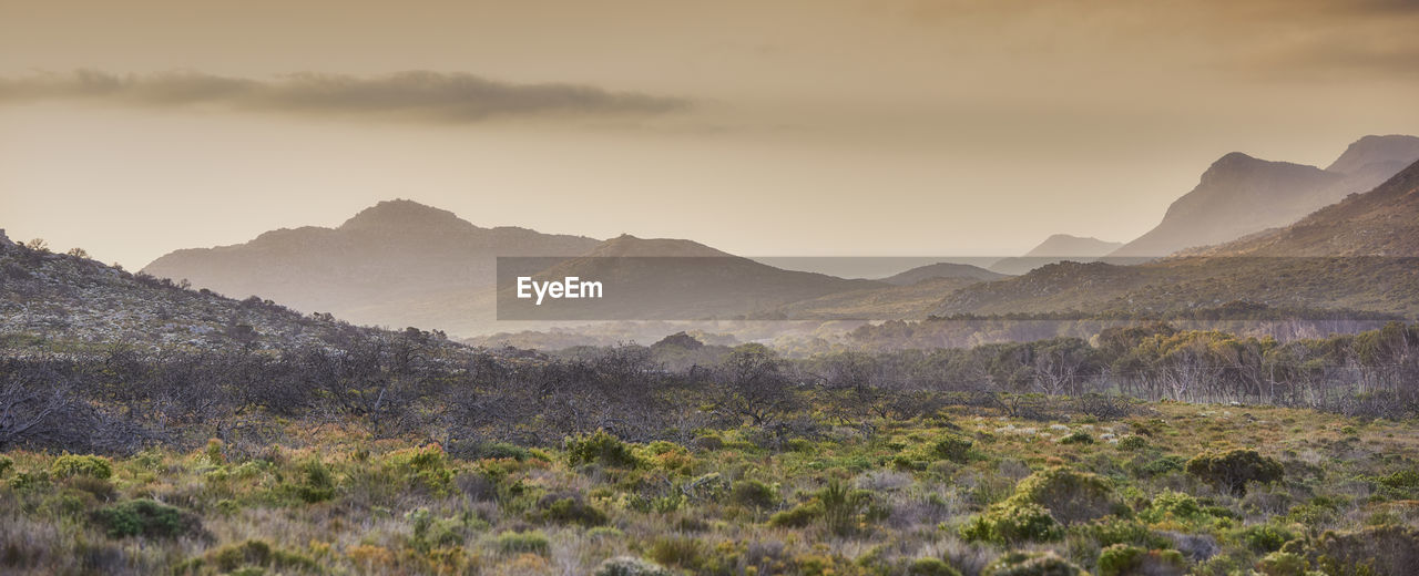 scenic view of mountains against sky at sunset