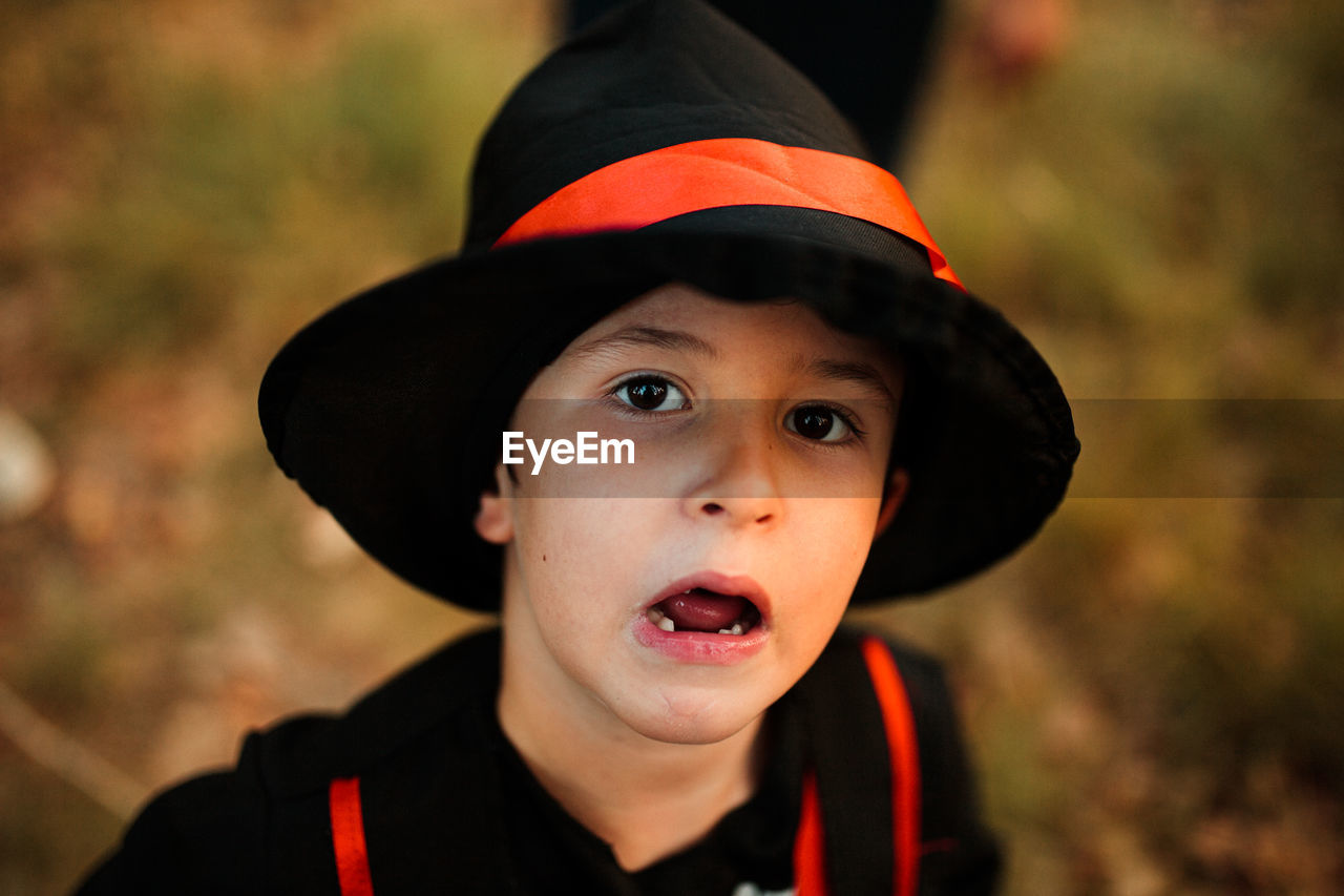 Close-up portrait of boy wearing hat during halloween at forest