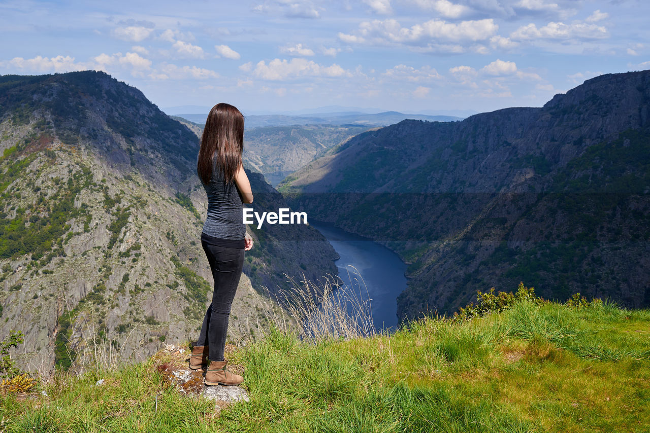 Woman standing on mountain against sky