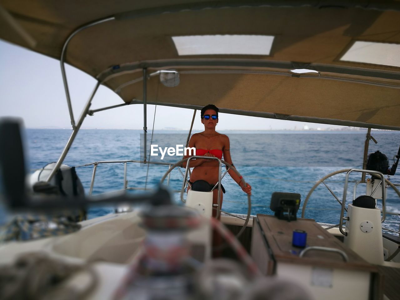 Young woman in bikini sailing yacht