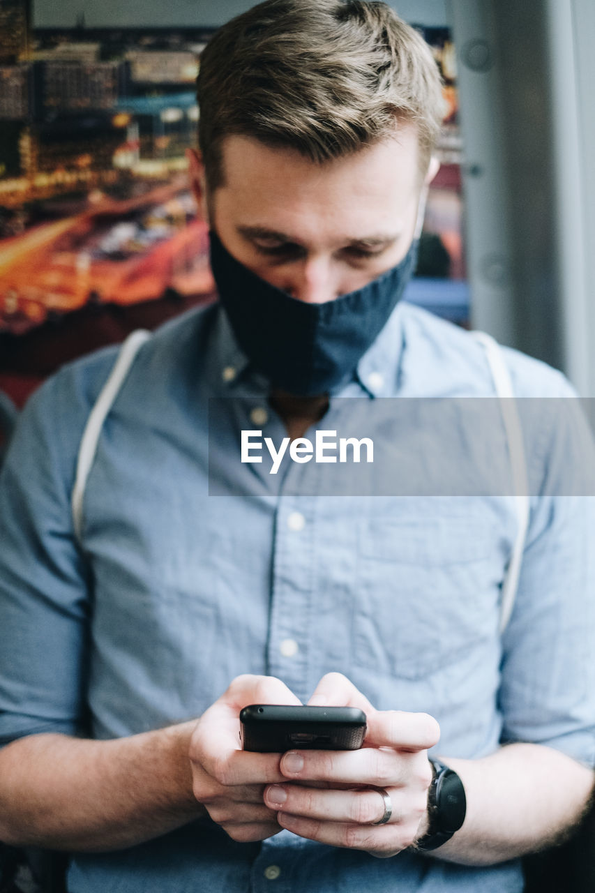 Man wearing mask using mobile phone