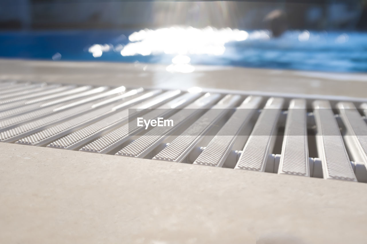 CLOSE-UP OF TABLE AND SWIMMING POOL